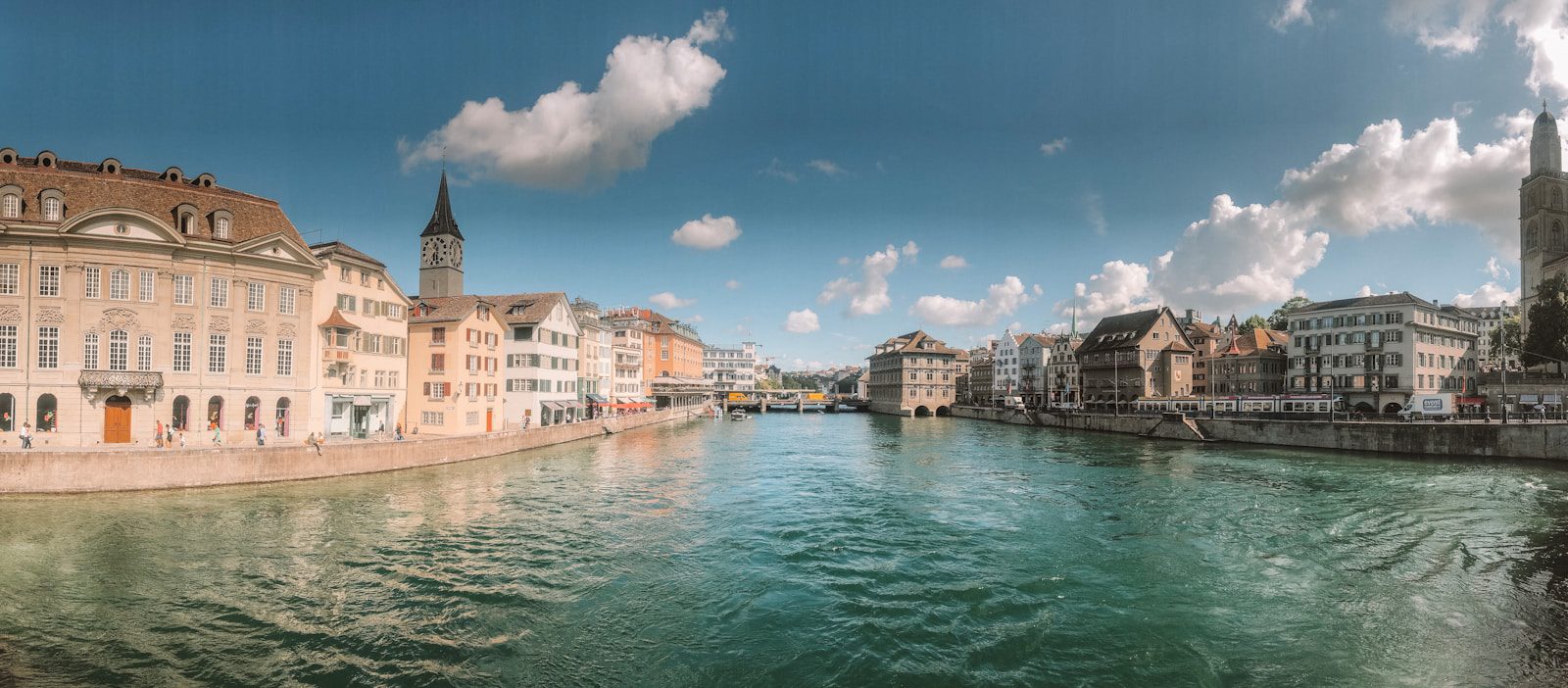 brown buildings near beside calm body of water