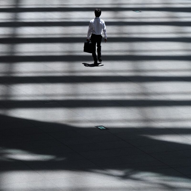 man holding laptop bag walking on street