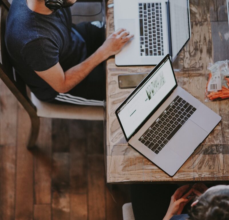 man sitting on chair and looking laptop computer